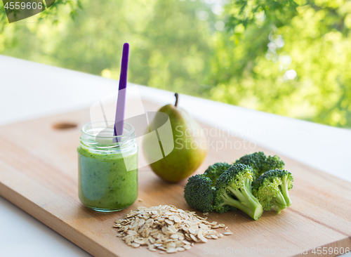 Image of jar with puree or baby food on wooden board