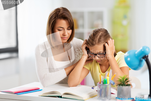 Image of mother helping daughter with difficult homework