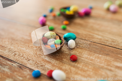 Image of chocolate egg and candy drops on wooden table