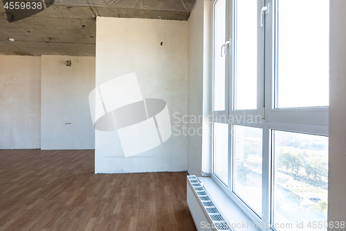 Image of Large stained glass window and battery in the interior of an empty room of a new building