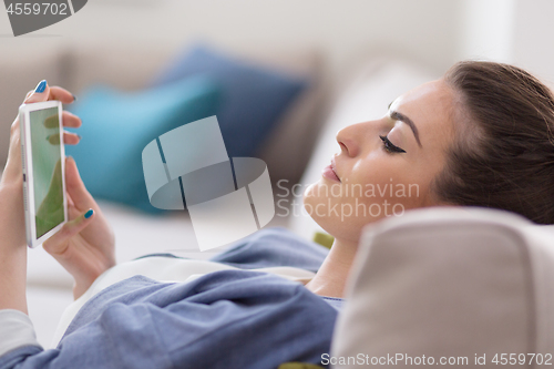 Image of woman on sofa using tablet computer