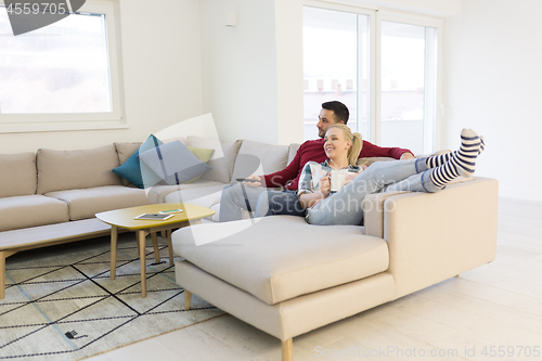 Image of Young couple on the sofa watching television