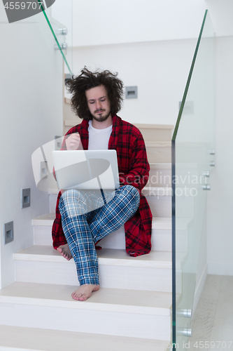 Image of freelancer in bathrobe working from home