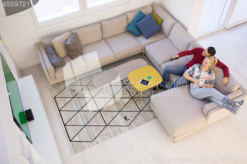 Image of Young couple on the sofa watching television