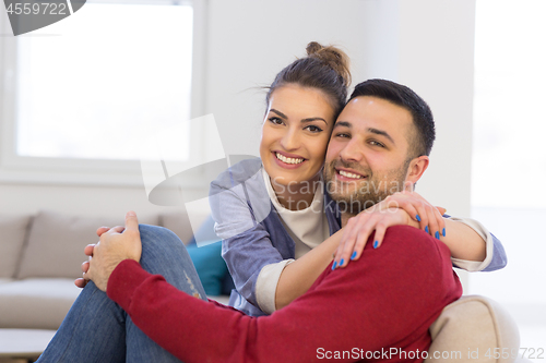 Image of couple hugging and relaxing on sofa