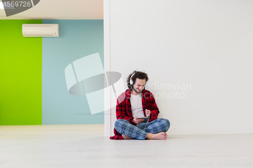 Image of young man enjoying music through headphones