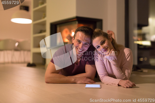 Image of Young Couple using digital tablet on cold winter night