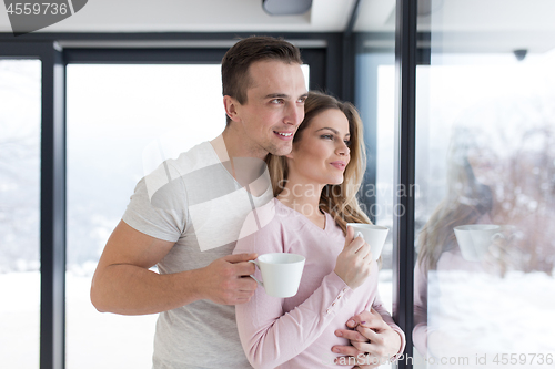 Image of young couple enjoying morning coffee by the window