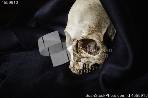 Image of Closeup photo an old skull covered in black robe