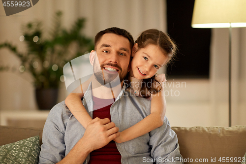Image of happy father and little daughter hugging at home