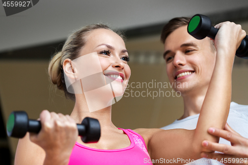 Image of woman with dumbbells exercising in gym