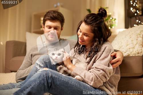 Image of happy couple with cat at home