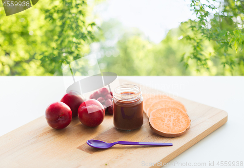 Image of fruit puree or baby food in jar and feeding spoon