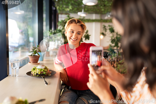 Image of women having lunch and photographing at cafe