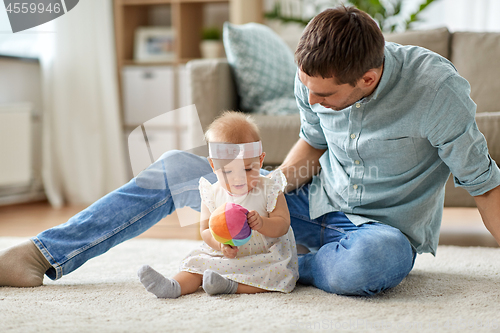 Image of father and little baby daughter with ball at home