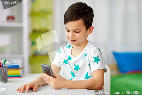 Image of happy boy with smartphone at home