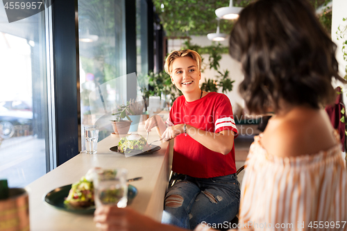 Image of female friends eating at restaurant