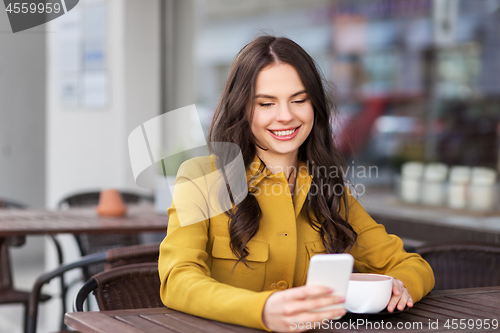 Image of teenage girl with smartphone and hot drink at cafe