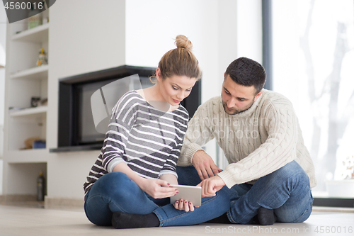 Image of Young Couple using digital tablet on cold winter day