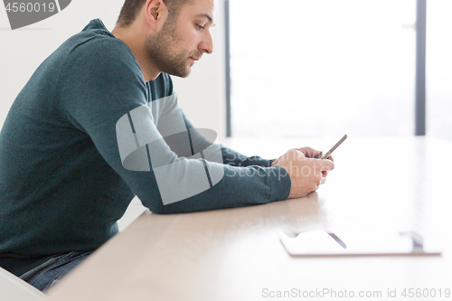 Image of Young casual businessman using smartphone