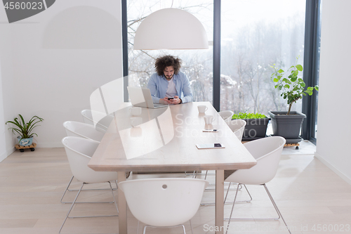 Image of Young casual businessman using smartphone