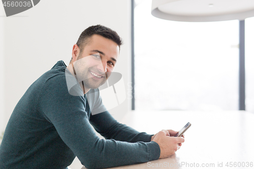 Image of Young casual businessman using smartphone