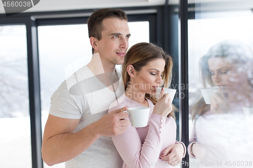 Image of young couple enjoying morning coffee by the window