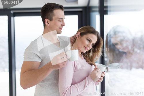 Image of young couple enjoying morning coffee by the window