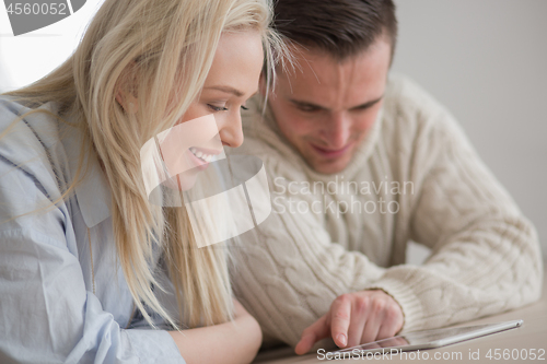 Image of Young Couple using digital tablet on cold winter day