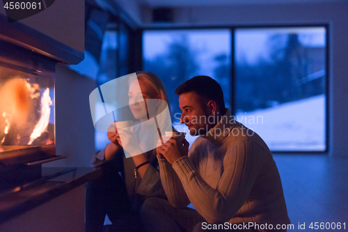 Image of happy couple in front of fireplace