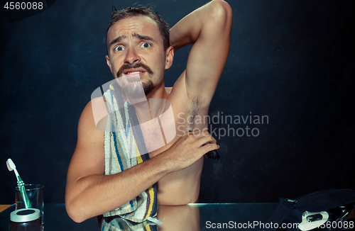 Image of Photo of handsome man shaving his armpit