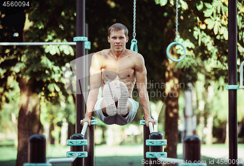 Image of Athlete doing exercises at stadium at park