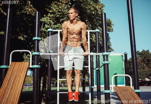 Image of Athlete doing exercises at stadium at park