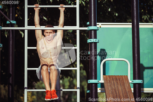 Image of Athlete doing exercises at stadium at park