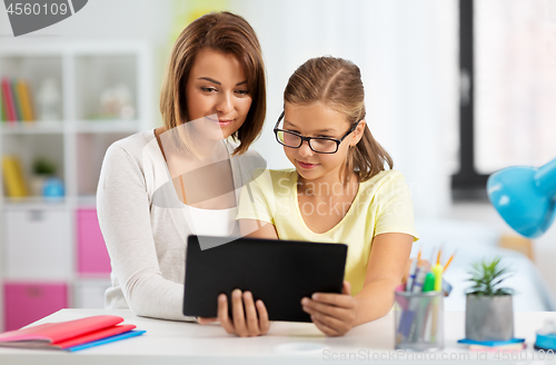 Image of mother and daughter with tablet pc doing homework