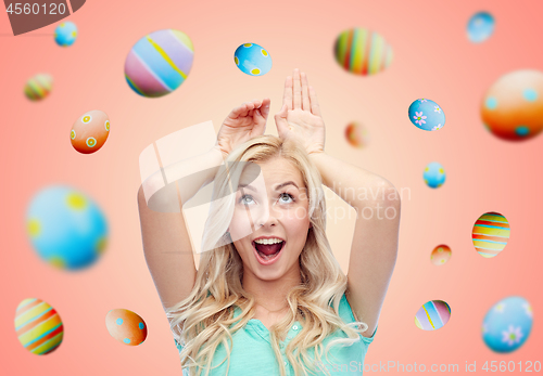 Image of happy smiling young woman making easter bunny ears