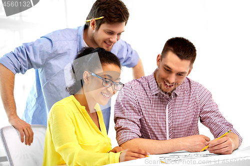 Image of creative team with blueprint working at office