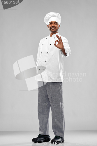 Image of happy male indian chef in toque showing ok gesture