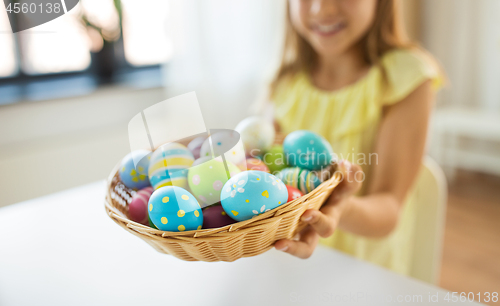 Image of close up of girl with easter eggs in wicker basket