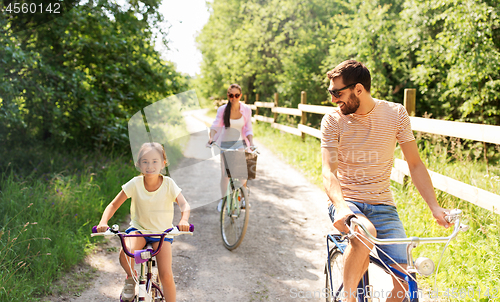 Image of happy family with bicycles in summer park