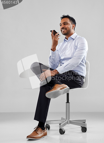 Image of businessman using voice recorder on smartphone