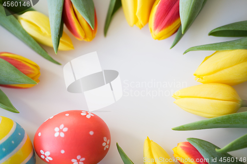 Image of close up of colored easter eggs and tulip flowers