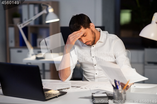 Image of businessman with papers working at night office