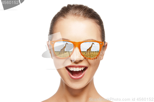 Image of happy teen girl in sunglasses looking at giraffes