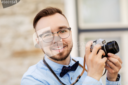 Image of photographer or hipster with film camera outdoors