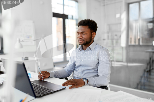 Image of african american businessman with laptop at office