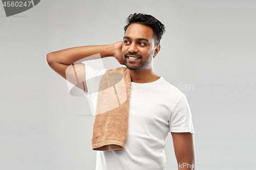 Image of smiling indian man with towel over grey background