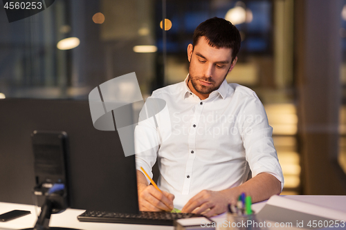 Image of businessman with computer working at night office