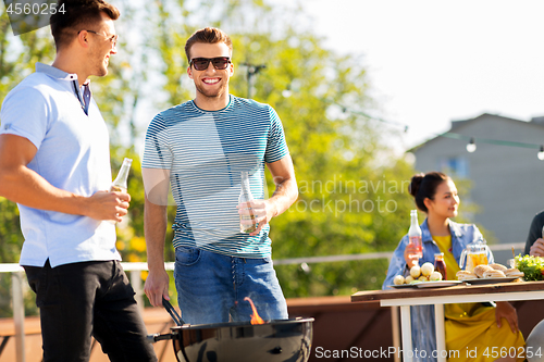 Image of happy friends having bbq party on rooftop