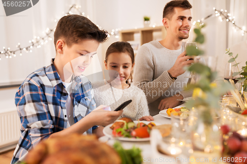 Image of children with smartphone at family dinner party